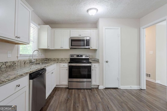3938 Emerald Springs Ct, Decatur, GA 30035 - kitchen featuring a sink, white cabinets, dark wood-type flooring, visible vents, and appliances with stainless steel finishes