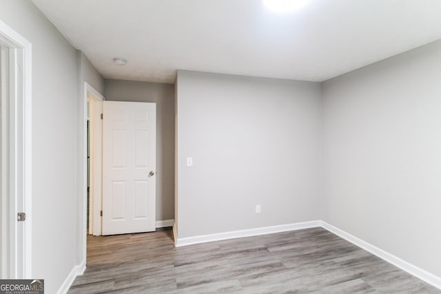 empty room with wood finished floors and baseboards