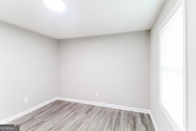 unfurnished room featuring baseboards and light wood-style floors