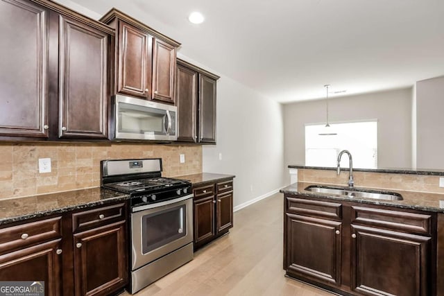 7843 Shertall St, Fairburn, GA 30213 - kitchen with dark stone countertops, stainless steel appliances, tasteful backsplash, and a sink