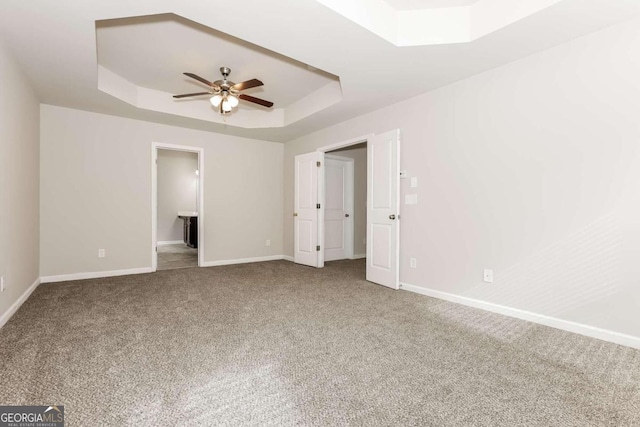 7843 Shertall St, Fairburn, GA 30213 - unfurnished bedroom with a tray ceiling, carpet floors, baseboards, and a ceiling fan