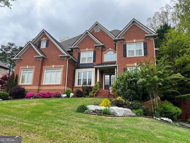 view of front of property featuring brick siding and a front yard