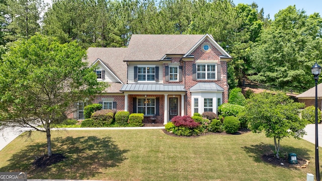 621 Oakbourne Way, Woodstock, GA 30188 - craftsman house featuring brick siding, a front yard, a shingled roof, and a standing seam roof