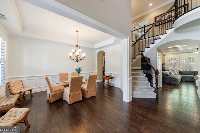 621 Oakbourne Way, Woodstock, GA 30188 - dining area featuring arched walkways, stairway, dark wood finished floors, ornamental molding, and a chandelier