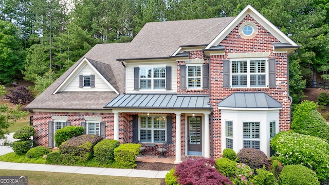 621 Oakbourne Way, Woodstock, GA 30188 - view of front of home featuring roof with shingles, brick siding, a standing seam roof, and a porch
