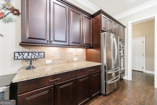 621 Oakbourne Way, Woodstock, GA 30188 - kitchen featuring appliances with stainless steel finishes, crown molding, dark wood-style floors, tasteful backsplash, and light stone counters