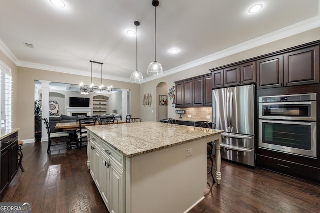 621 Oakbourne Way, Woodstock, GA 30188 - kitchen featuring ornate columns, stainless steel appliances, a kitchen breakfast bar, a kitchen island, and dark brown cabinets