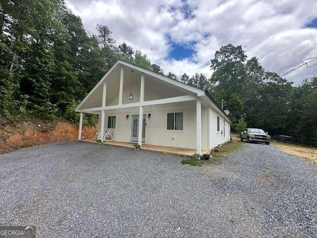 view of front of house featuring a porch and gravel driveway