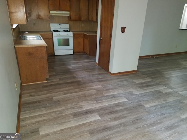 3208 Berrong Way, Stone Mountain, GA 30087 - kitchen featuring white gas range, exhaust hood, a sink, dark wood-type flooring, and baseboards
