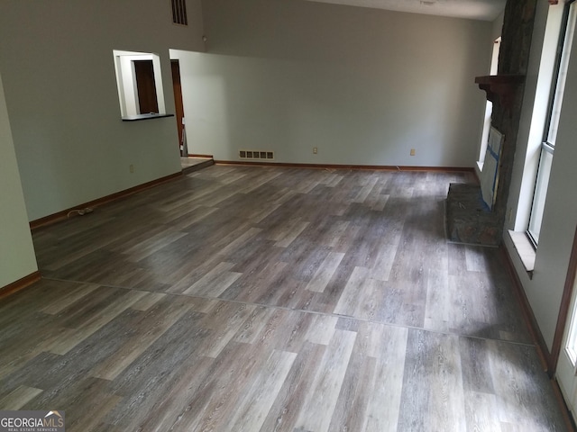 3208 Berrong Way, Stone Mountain, GA 30087 - unfurnished living room with a fireplace with raised hearth, wood finished floors, and baseboards