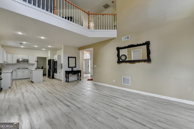 unfurnished living room with light wood finished floors and visible vents
