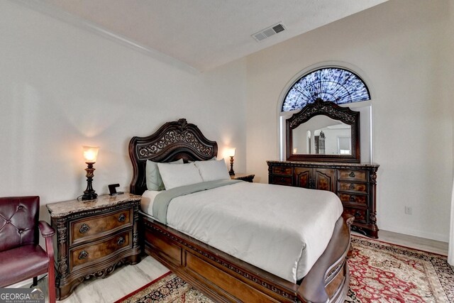 bedroom featuring light wood finished floors and visible vents