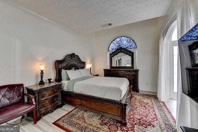 bedroom with arched walkways, ornamental molding, visible vents, and a textured ceiling