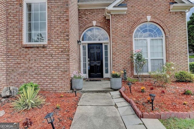 view of exterior entry with brick siding