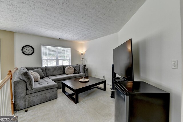 living area featuring light carpet and a textured ceiling