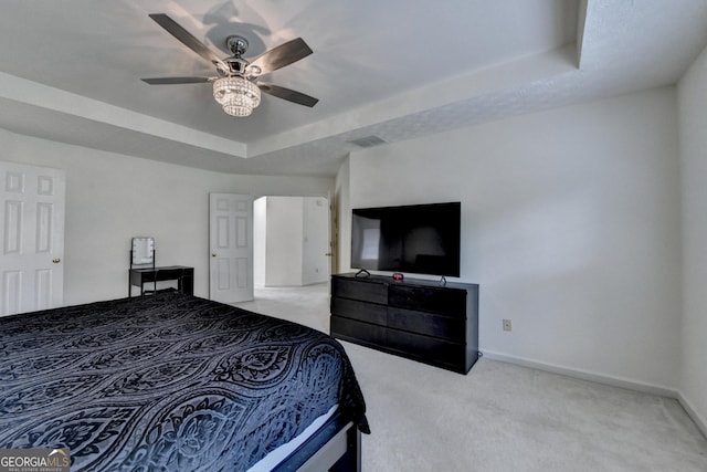 carpeted bedroom featuring baseboards, ceiling fan, a tray ceiling, and visible vents