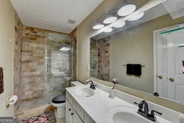 full bath with toilet, visible vents, a stall shower, and a sink
