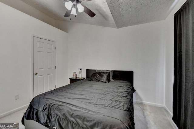 carpeted bedroom with a textured ceiling, baseboards, and a ceiling fan