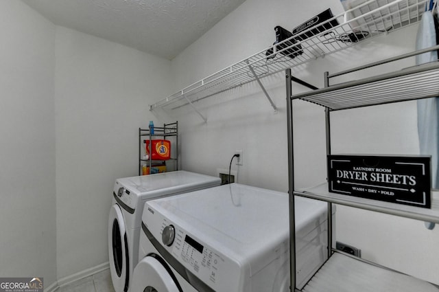 washroom with laundry area, baseboards, and washing machine and dryer