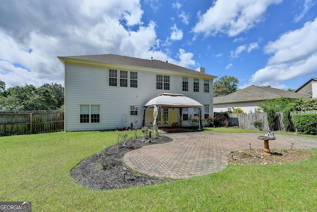back of property featuring a gazebo, a yard, a patio, a fenced backyard, and a chimney
