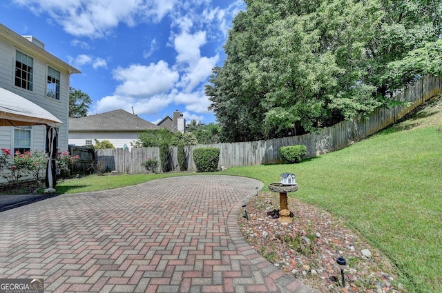 view of patio with decorative driveway and a fenced backyard