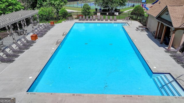 pool featuring a pergola and fence