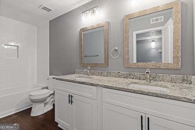 full bathroom with toilet, visible vents, a sink, and wood finished floors