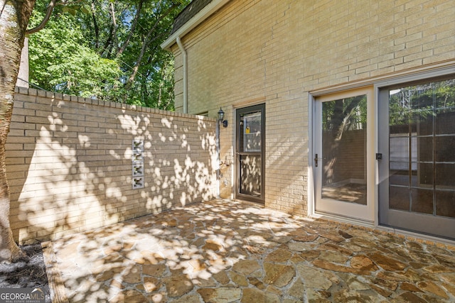 exterior space with fence, a patio, and brick siding
