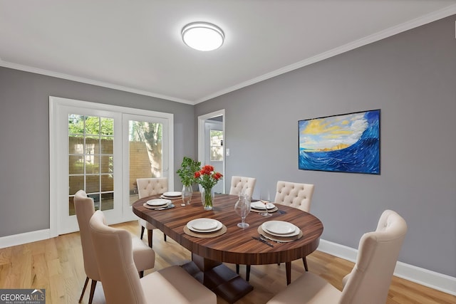 dining room featuring ornamental molding, baseboards, and light wood-type flooring