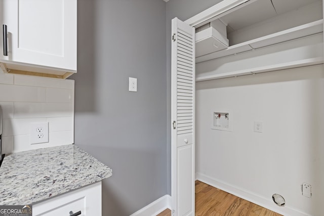 laundry room featuring baseboards, hookup for a washing machine, laundry area, and light wood-type flooring