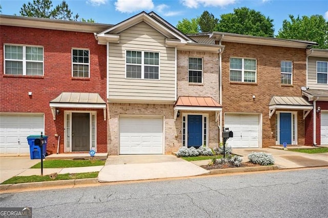 multi unit property with driveway, brick siding, and a garage
