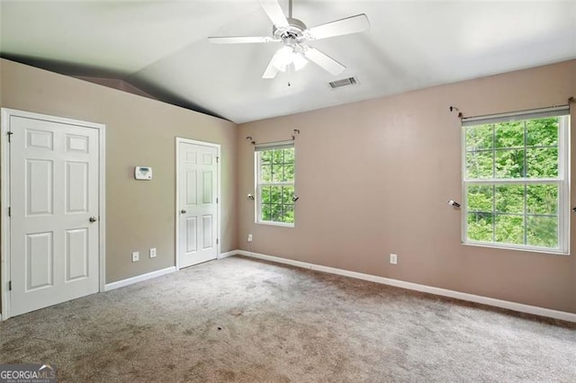 unfurnished bedroom with carpet, baseboards, ceiling fan, visible vents, and vaulted ceiling