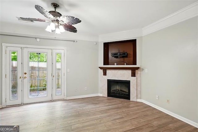 unfurnished living room with ceiling fan, crown molding, baseboards, and wood finished floors