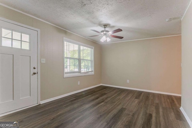 foyer with a textured ceiling, dark wood-style flooring, crown molding, ceiling fan, and baseboards