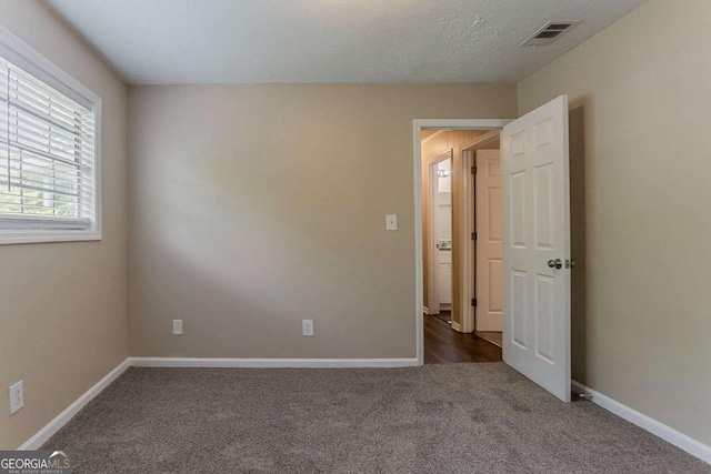 carpeted empty room with baseboards and visible vents