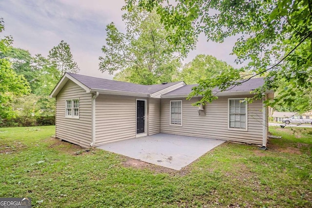 back of property with a patio area and a lawn