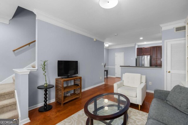 living room featuring crown molding, stairs, wood finished floors, baseboards, and recessed lighting