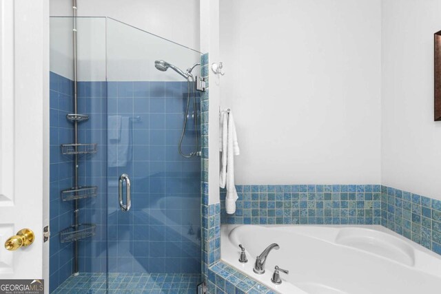 bathroom featuring a shower stall and a garden tub