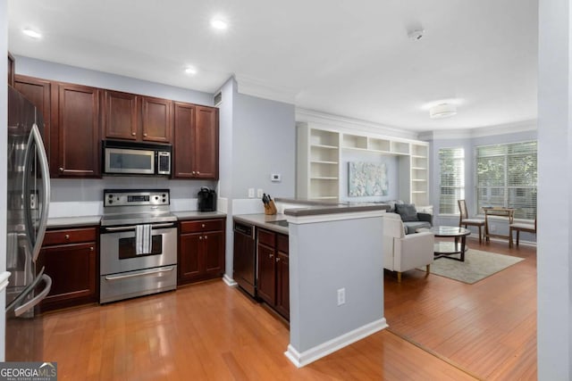 kitchen with stainless steel appliances, a peninsula, open floor plan, light wood finished floors, and crown molding