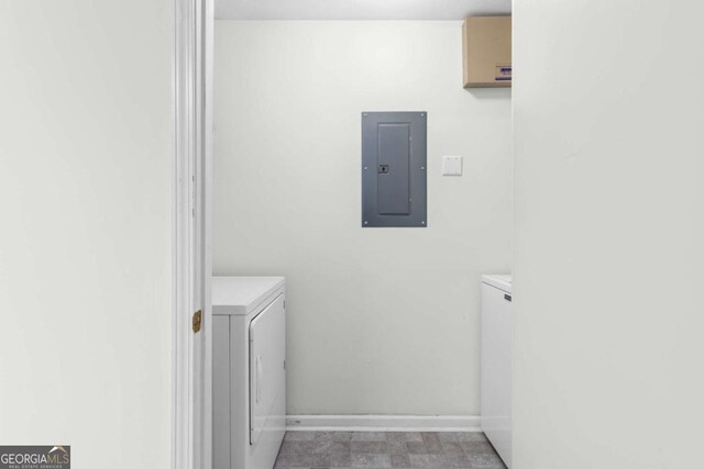 washroom with washer and dryer, electric panel, and baseboards