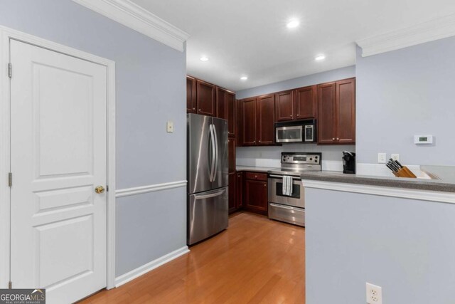 kitchen with appliances with stainless steel finishes, ornamental molding, light wood-style flooring, and recessed lighting