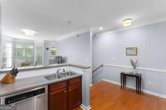 kitchen with dishwasher, ornamental molding, a sink, light wood-type flooring, and recessed lighting