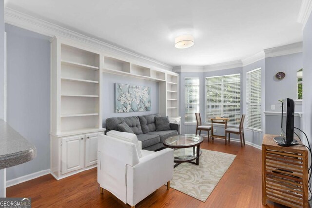 living room with baseboards, dark wood finished floors, ornamental molding, and built in shelves