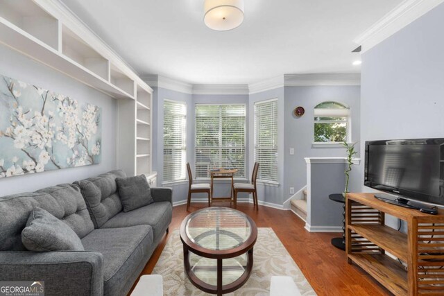 living room featuring dark wood-style floors, crown molding, and baseboards