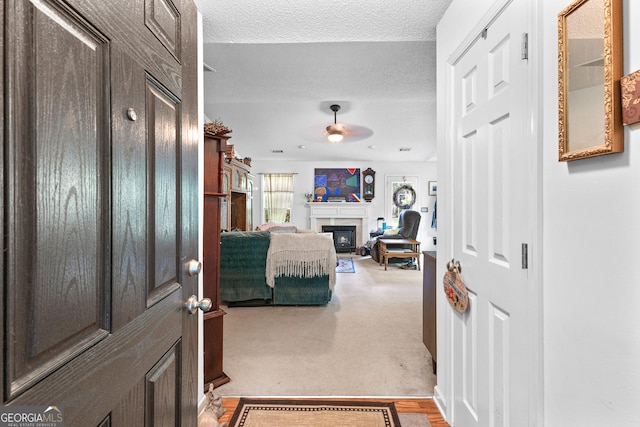 425 W Ridgeway Rd, Maysville, GA 30558 - foyer with a fireplace, a textured ceiling, a ceiling fan, and carpet