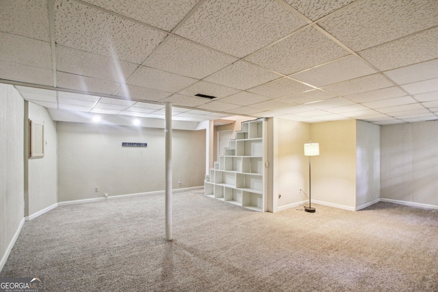 finished basement with baseboards, a paneled ceiling, visible vents, and carpet
