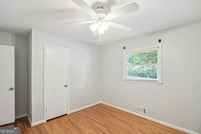 unfurnished bedroom featuring light wood-type flooring, baseboards, visible vents, and a ceiling fan