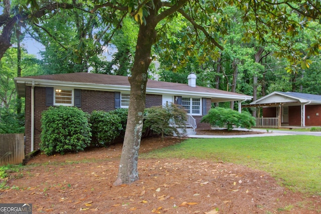 single story home with a porch, fence, a front lawn, and brick siding