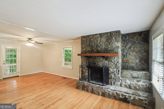 unfurnished living room featuring baseboards, wood finished floors, a fireplace, and ceiling fan