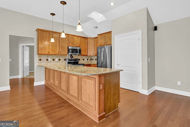 308 Jessica Way, Canton, GA 30114 - kitchen featuring stainless steel appliances, a skylight, a peninsula, vaulted ceiling, and tasteful backsplash